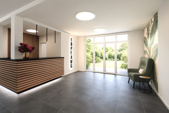 Moderne Empfangshalle mit Holztheke, grüner Sitzecke und Blick auf den Garten.